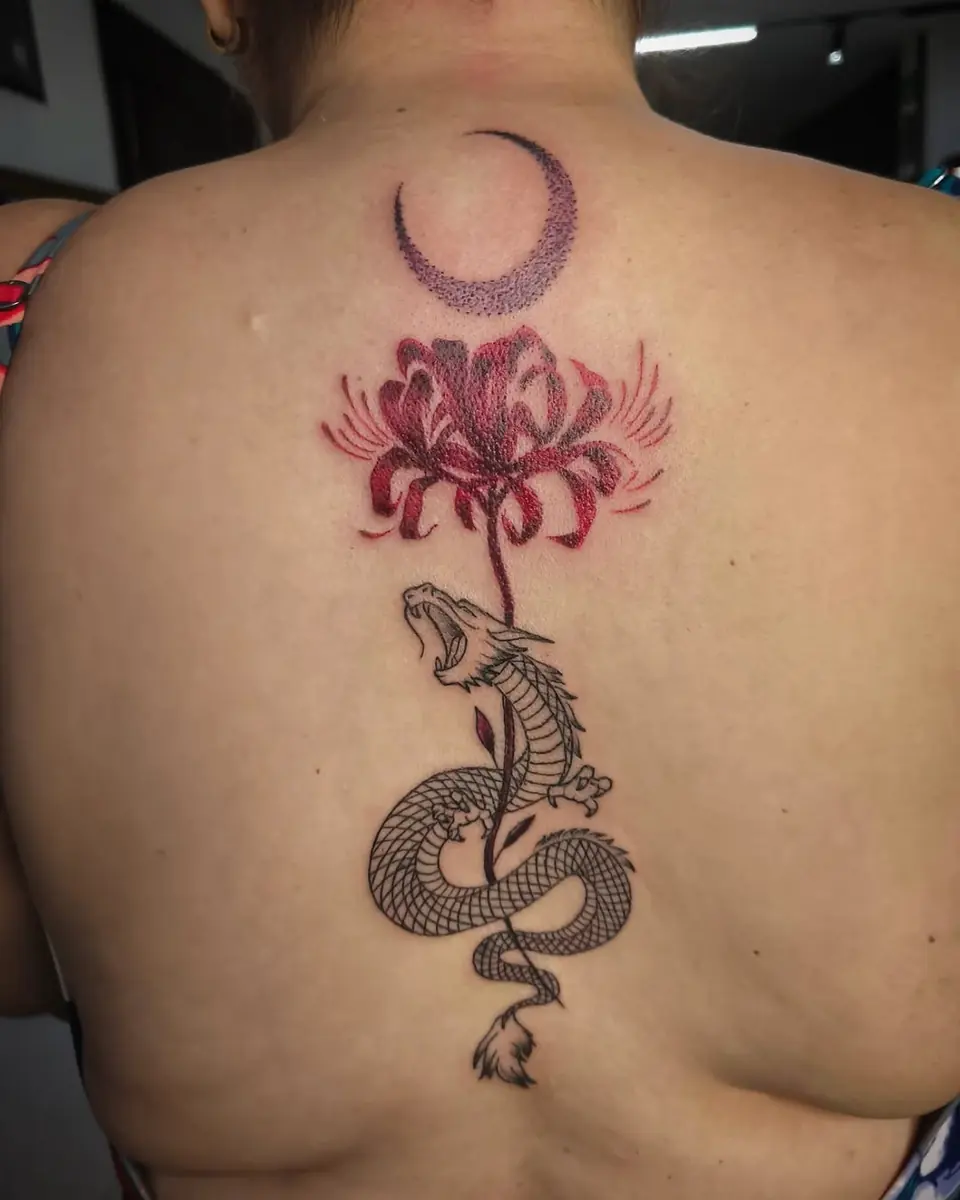 Tatuaje fine line en la espalda con una luna, un lirio rojo y una serpiente, por Jenn Tatts