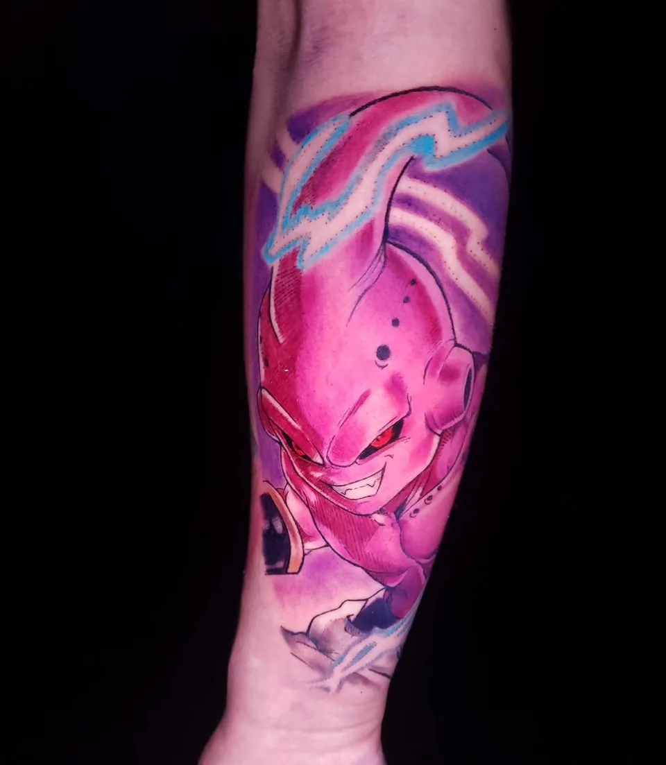 Tatuaje a color de Majin Buu, de Dragon Ball, en el antebrazo, por Jenn Tatts