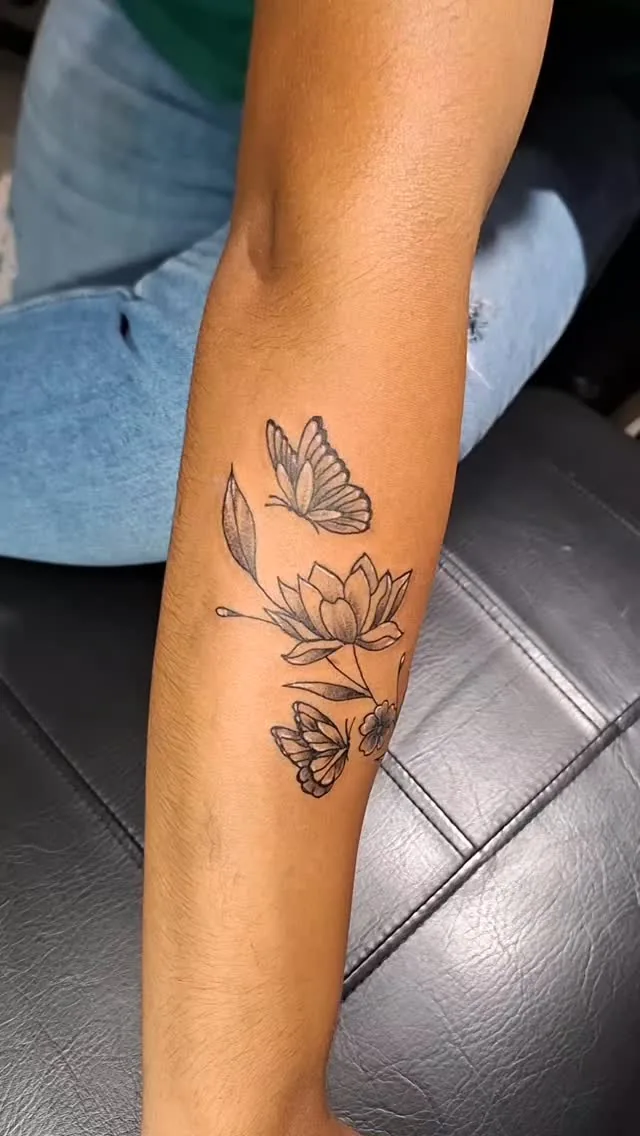 Tatuaje de mariposas y una flor de loto en la pierna, por Kewyn Romero