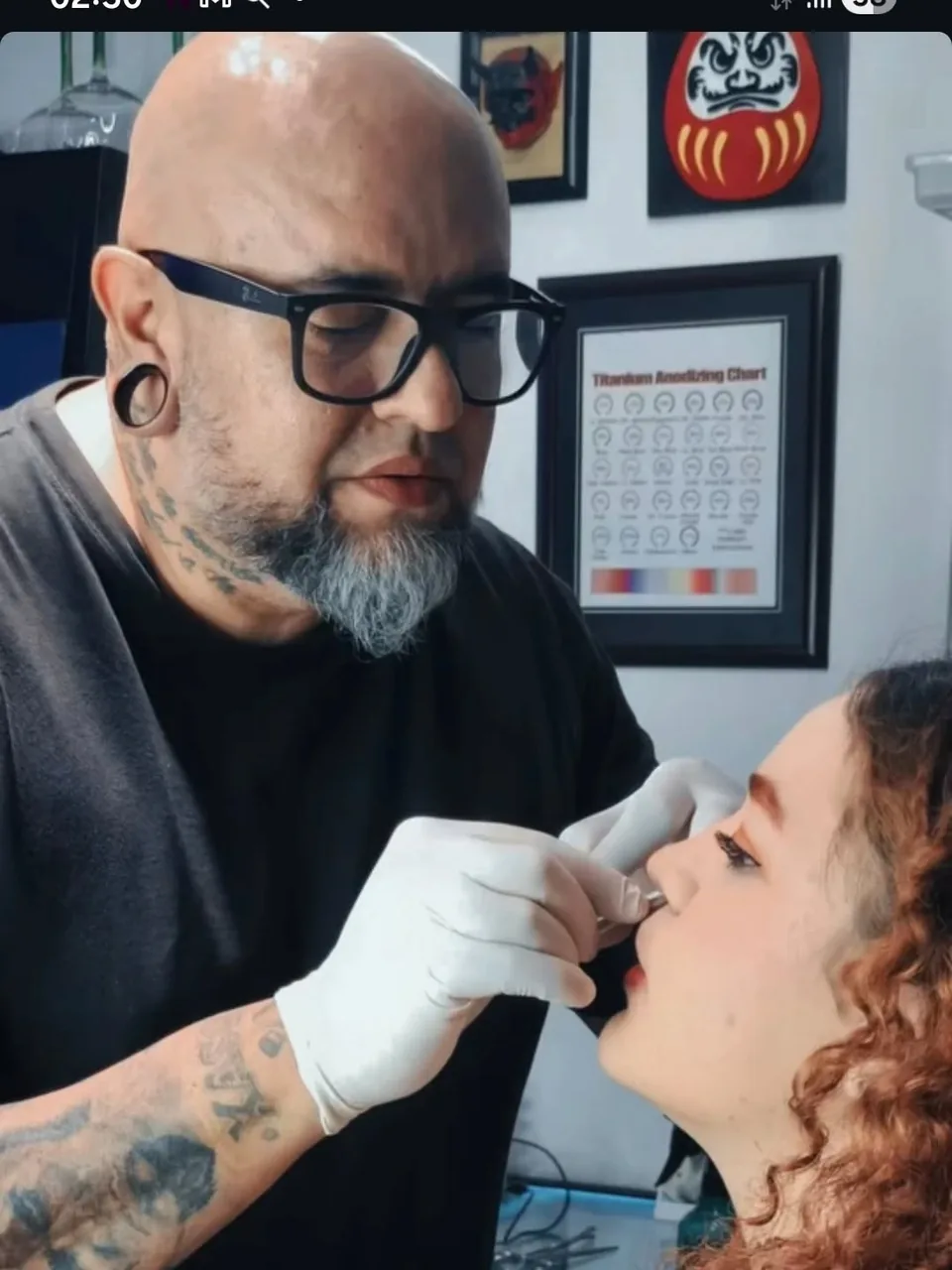 Perforación de nariz en proceso: el perforador trabaja con guantes en el estudio