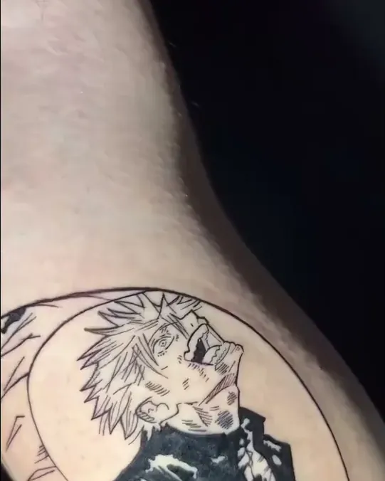 Tatuaje anime en blanco y negro de un personaje de Jujutsu Kaisen dentro de un círculo, en el brazo