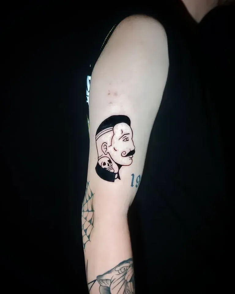 Tatuaje de un retrato estilo cómic en blanco y negro en el brazo