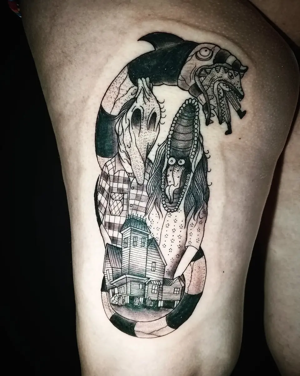Tatuaje en black and grey inspirado en Beetlejuice, con el gusano de arena y la casa, en el muslo, por Victor Hugo